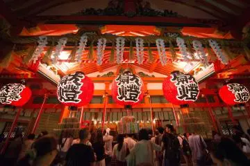 <p>ผู้คนเดินทางมาขอพรในตัวศาลเจ้ายามค่ำคืน</p>