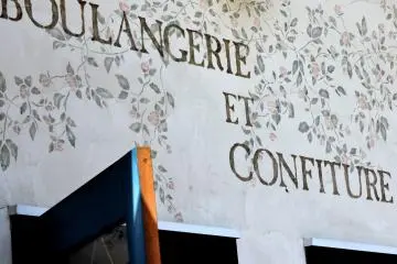 The bakery sign has stenciled lettering, leaves and flowers.