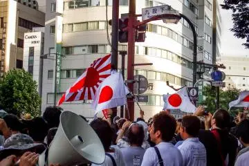 <p>A large crowd gathers at a crossing close to the exit of Kudanshita Metro Station</p>