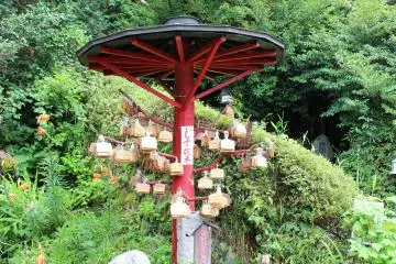 <p>Wooden emma tablets with wishes hanging from a wooden parasol</p>