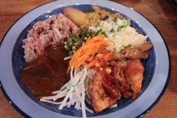 Buffet plate with curry and vegetable side dish selection.