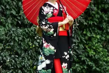 <p>A bride in traditional kimono poses for pictures in the garden</p>