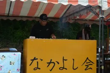 A man at his food stall, the sign reads "Let's Be Friends Association" (Photo: Sarah Elisabeth Chaney)