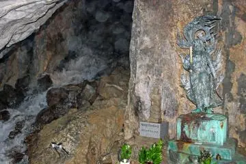 <p>The main chamber of the cave, the waterfall and a statue of Fudomyo, the Buddhist deity of discipline</p>