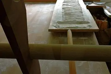 <p>Les nouilles coup&eacute;es &agrave; la main sur la planche</p>