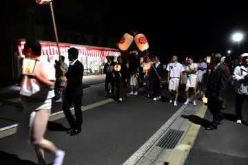 <p>Lion bearers marching down the street at night</p>