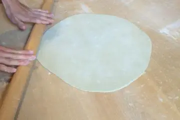 처음에 손을 사용한 후에, 우리는 롤링 핀을 사용하여 그것을 더 얇게 만들었다.