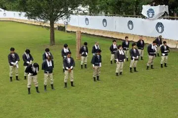 The 18 seko participating in the first day's ceremony bow their heads to receive a blessing during the opening prayer