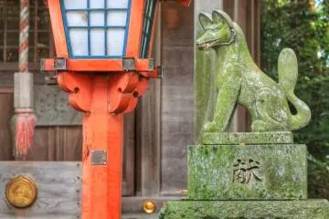 Une lanterne rouge et l'une des statues de renard