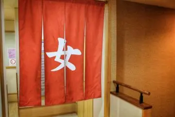 <p>The red curtain reads "onna" (female)</p>