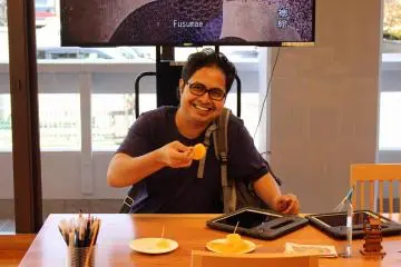 <p>A traveler enjoys a slice of kaki</p>