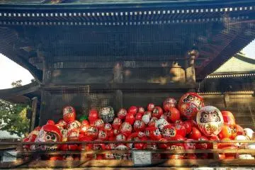 <p>Boneka-boneka ditumpuk di depan ruang utama tempat berdoa menunggu untuk dibakar selama proses upacara agama Buddha</p>