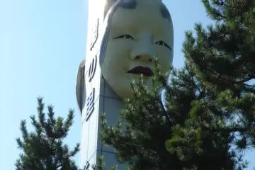 Statue of Noh mask by the terminal building in Ryotsu Port
