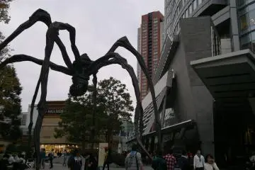 <p>Statue of Maman and Mori Tower during the day.</p>