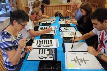 <p>Visitors from Australia and France try their hand at shodo</p>