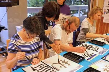 <p>An instructor shows the technique and stroke order of "aki," meaning autumn</p>