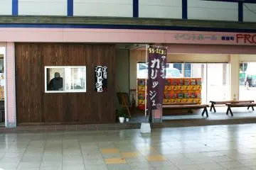 The front of the shop from the shopping arcade, with benches for waiting.