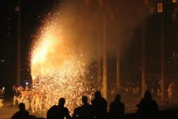 The crowd watches as the men bathe themselves in firework sparks.