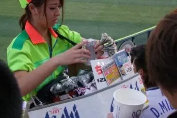 A beer vendor busy keeping the thirsty fans happy.