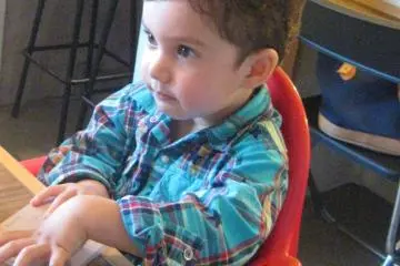 My son seated in the high chair.