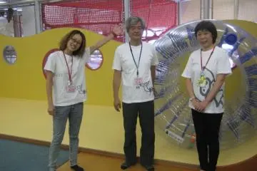 Staff in front of a clear rolling wheel that kids older than three can try out (Photo: S. C. Kurokawa)