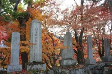 <p>Stone monuments and fiery leaves across the street from Ryusenji</p>
