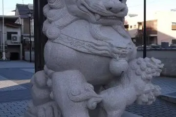 <p>One of the guardian lions at the gate, with a cub at its paw</p>
