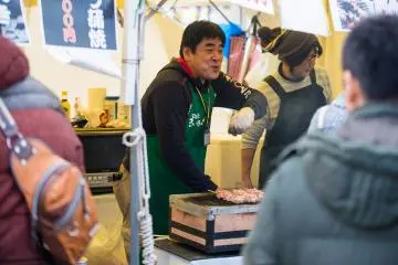 <p>Entertaining his customers as he grill his sausages</p>
