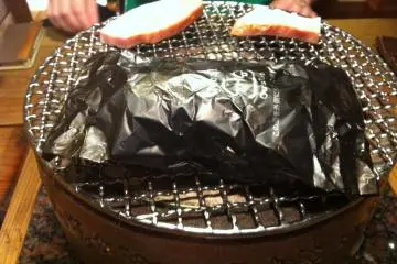 Meat and a potato grilling nicely