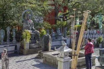 A woman prays to the Jizō Bodhisattva to watch over the souls of the infants