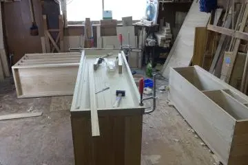 Wooden planks are assembled into the shape of a chest of drawers