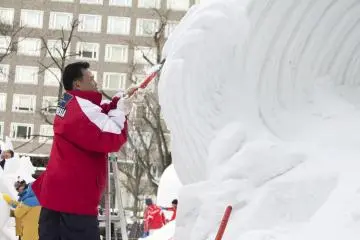 A man hard at work on his snow sculpture