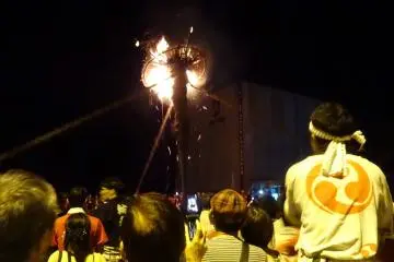 Locals and visitors watch a taimatsu burn down; who will catch the gohei this year?