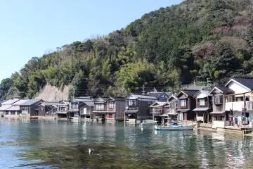 Boathouses line the shore at Ine Town