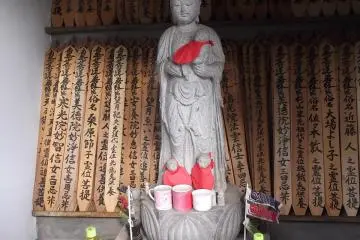 A small statue with grave markers and offerings