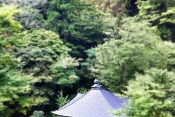 The pretty Daishi-do beneath a large Buddhist image in a cliff cave