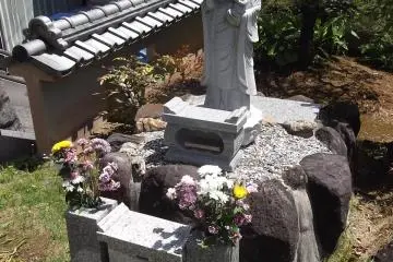 A smaller statue next to the Kannon