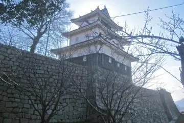 The sun casts a halo behind the castle tower