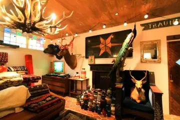 Carpets, pottery, deer heads, and various items for sale