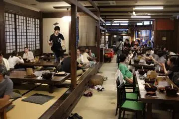 Traditional tatami-style booth and several wooden tables and chairs 