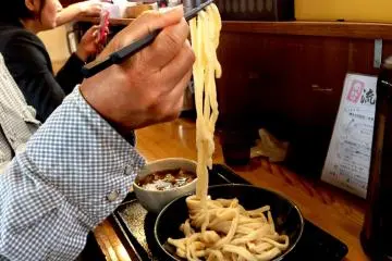 Lifting the cold noodles into the hot soup