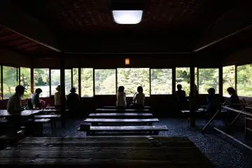 Des visiteurs se reposant dans le pavillon du jardin Keitaku-en