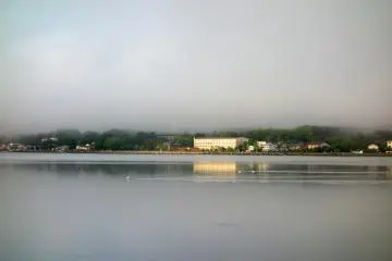  La lumière du soleil touche le lac Yamanaka. Apparemment, elle ramène à la vie le village car on peut alors voir les voitures commencer à circuler le long des routes et les devantures de magasins s'ouvrir