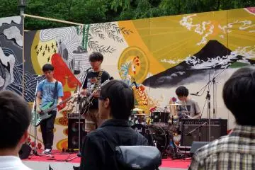 On the outside stage, the university's local rock band strum some tunes to a crowd of current and prospective students and parents