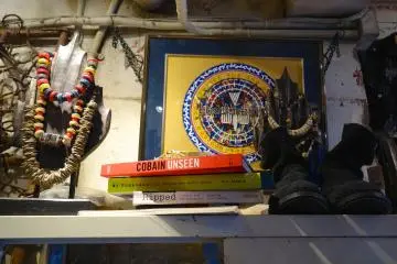 A shop displays American Indian art and English-titled books on fashion
