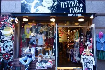 The store owner sits outside relaxedly, observing passerby's and accepting postal packages