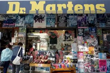 Two people stop to rub the shiny Dr. Martens on display