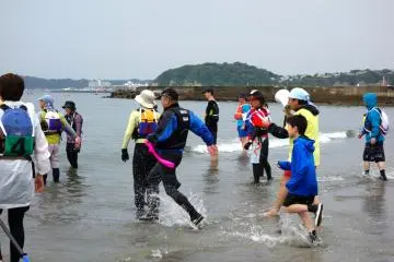 A pair dash back to the team's kayak after running to the beacon to hand over the sash to the next pair