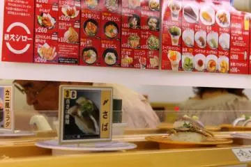 As soon as you take your seats, dishes of sushi pass by your table on the rolling conveyor belt, inviting you to take them...