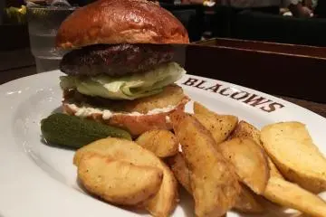 Hamburger with lettuce and grilled pineapple with steak fries on the side